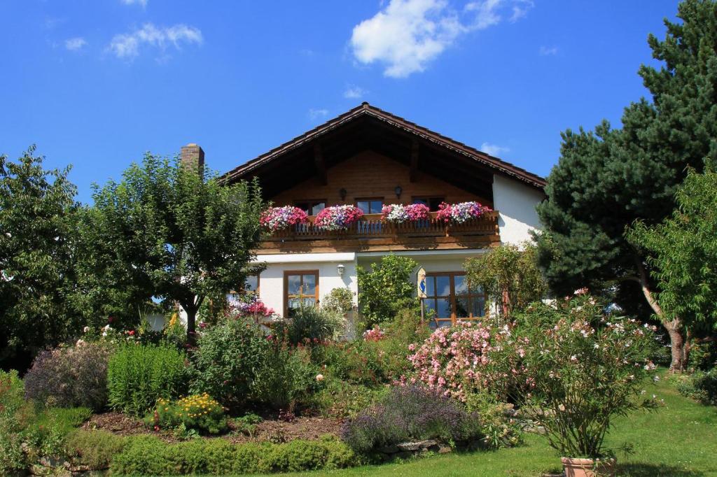 een huis met bloembakken op het balkon bij Apartment-Ferienwohnung Penzkofer in Zandt