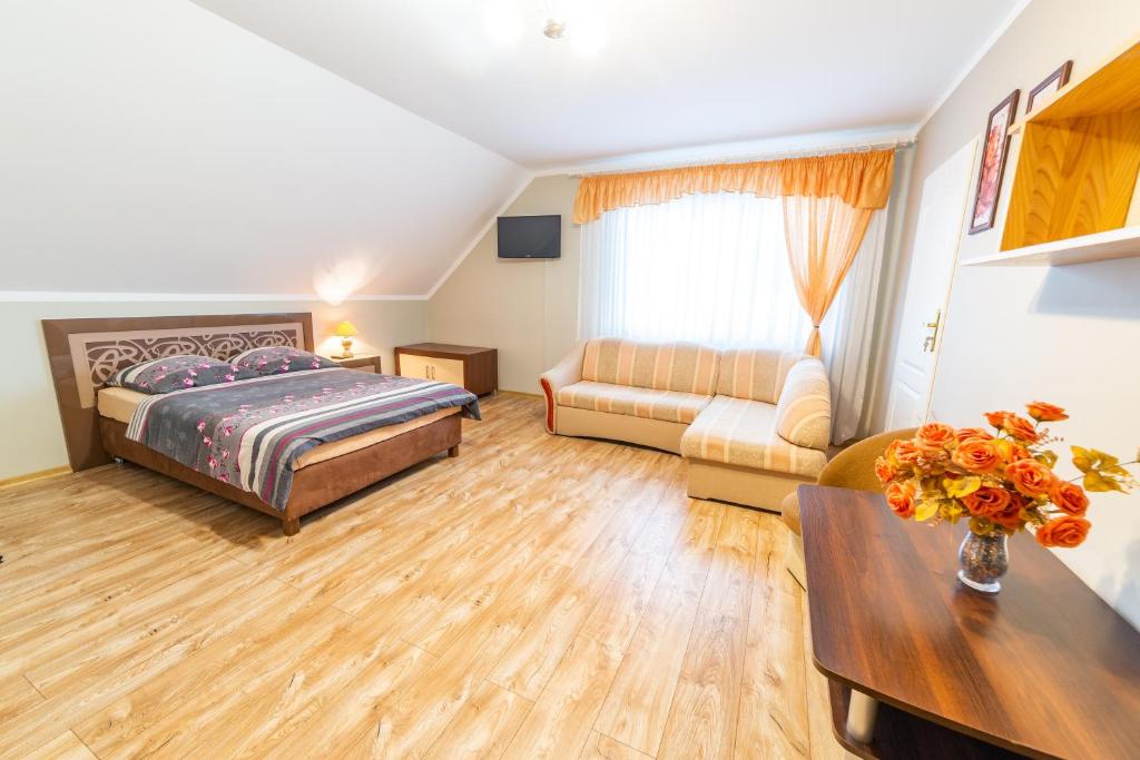a large bedroom with a bed and a couch at Pokoje Mirada in Mikołajki