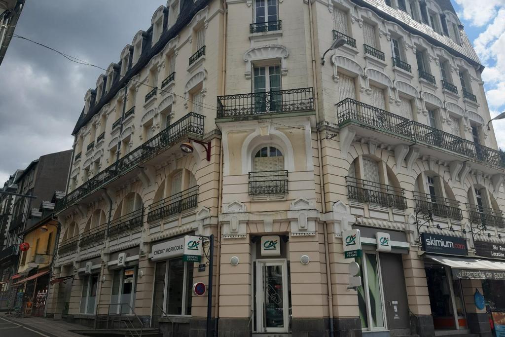 un grand bâtiment au coin d'une rue dans l'établissement Appartement en hyper centre, à Le Mont-Dore