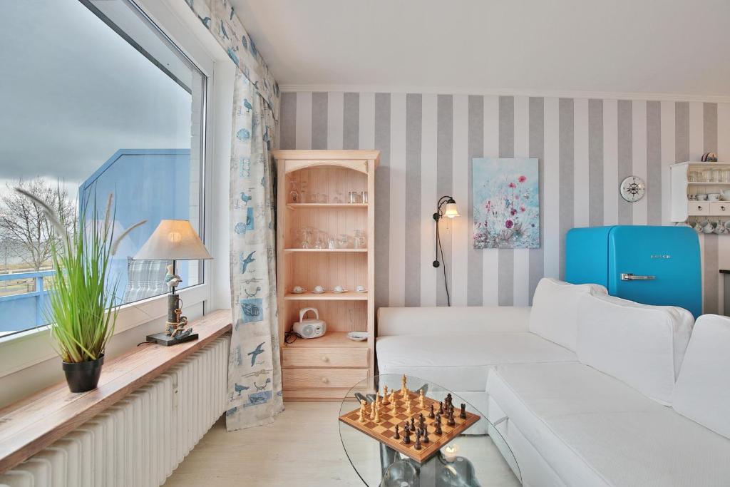 - un salon avec un canapé blanc et une table dans l'établissement Seetempel Seetempel Appartement 38, à Scharbeutz