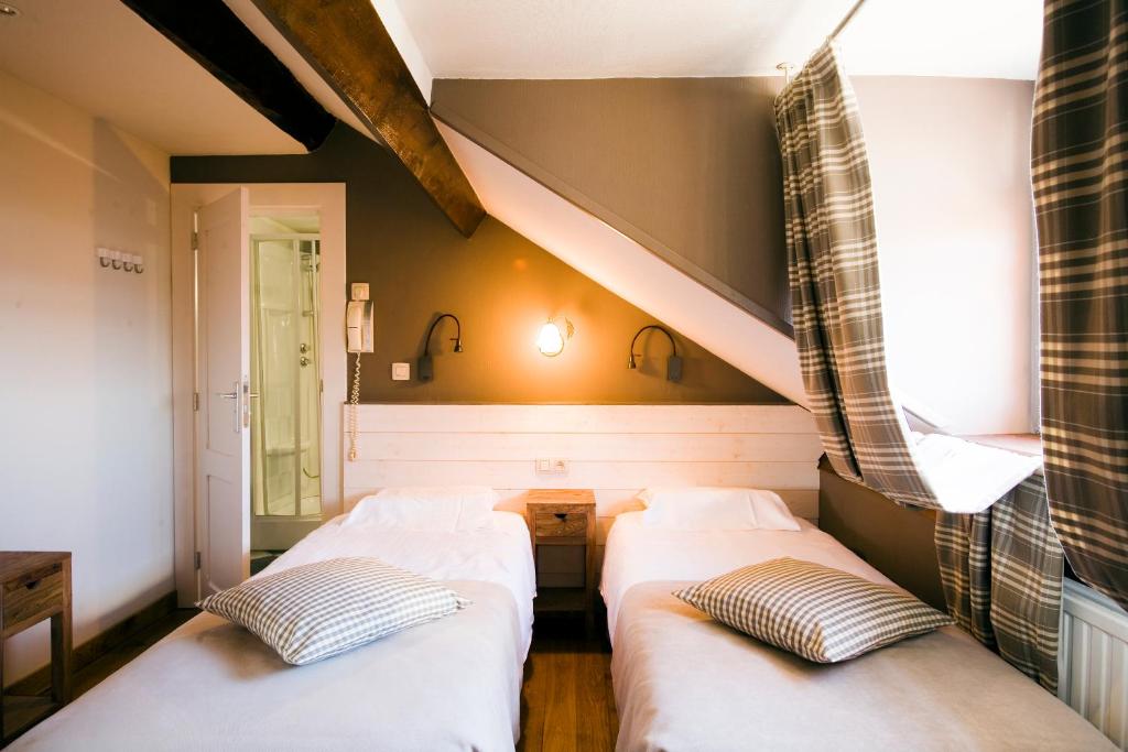 twee bedden in een kamer met een trap bij La Fontaine du Sabotier in Awenne