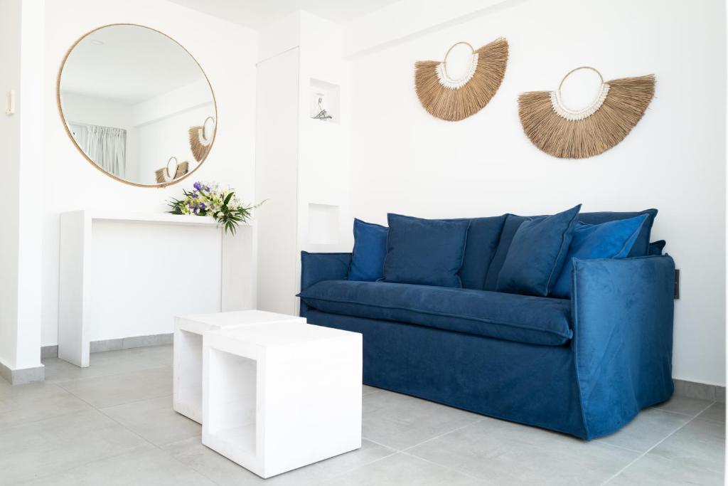 a living room with a blue couch and a mirror at Blue Harbour Boutique in Ayia Napa