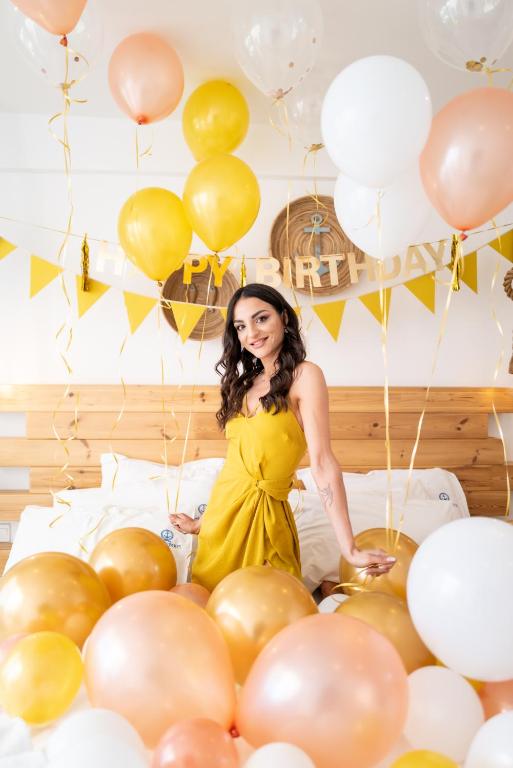 a woman in a yellow dress in a room filled with balloons at Blue Harbour Boutique in Ayia Napa