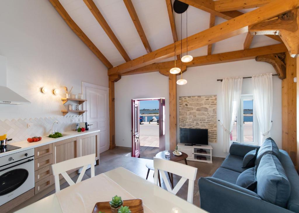 kuchnia i salon z niebieską kanapą w obiekcie Avali Design Suites by Imagine Lefkada w mieście Leukada (miasto)