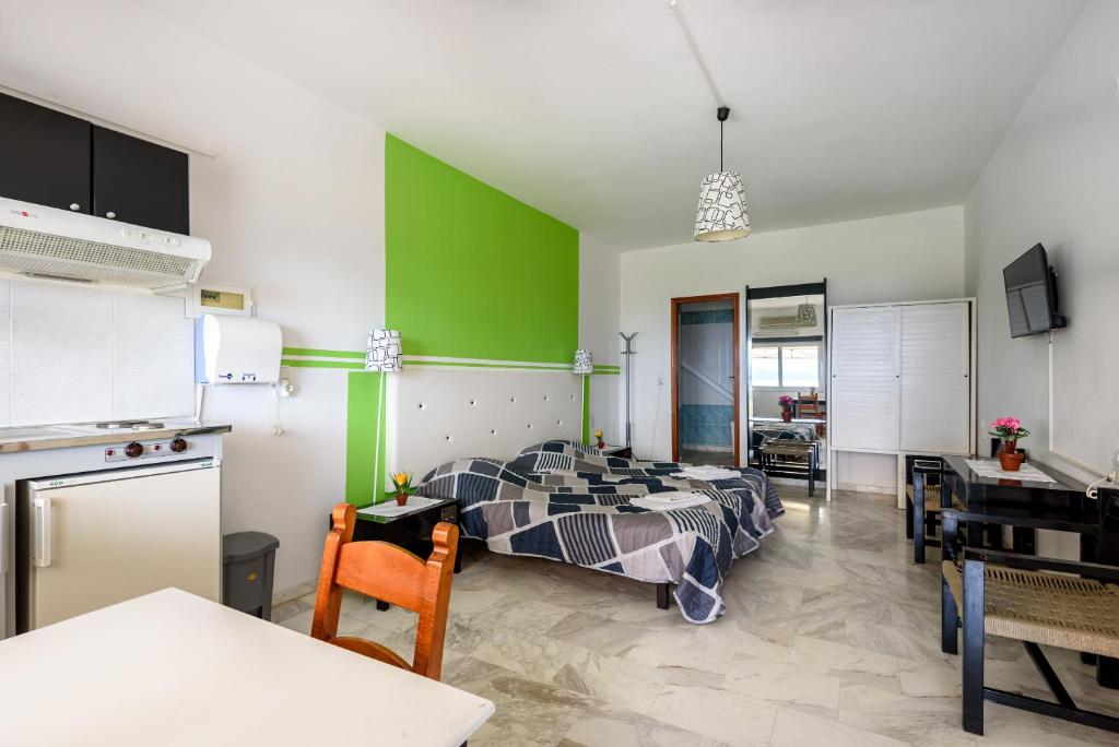 a bedroom with a bed and a green wall at Angela Apartments new listing in Marathi