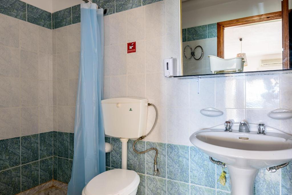 a bathroom with a toilet and a sink at Angela Apartments new listing in Marathi