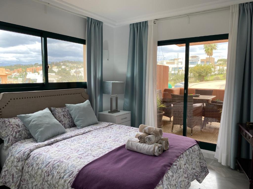un osito de peluche sentado en una cama en un dormitorio en Marbella Cabopino golf and beach only Adults, en Marbella