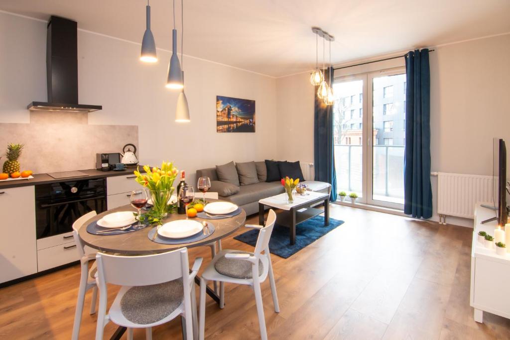 kuchnia i salon ze stołem i krzesłami w obiekcie Maya's Flats & Resorts 51 - Aura 40 w Gdańsku