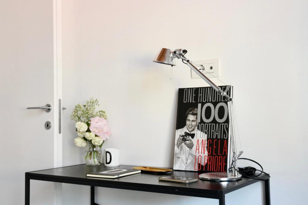 czarny stół z lampą i książką w obiekcie L’atelier di Porta Venezia w Mediolanie