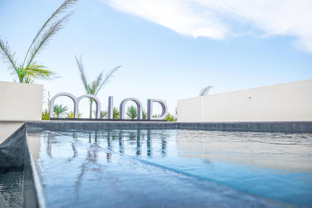 una piscina con un cartel que diga hotel en MAJESTIC MIND VUE MER LUXE CENTRE PARKING 8 MAX - CoHôteConciergerie La Grande Motte en La Grande-Motte