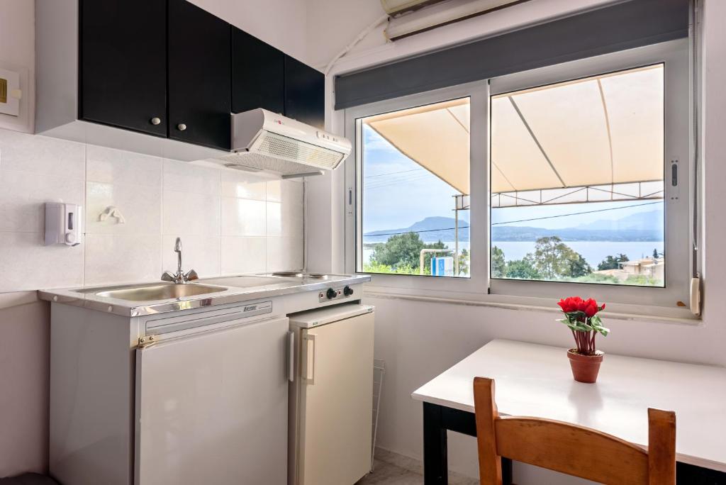 a kitchen with a table and a sink and a window at Angela Apartments new listing in Marathi