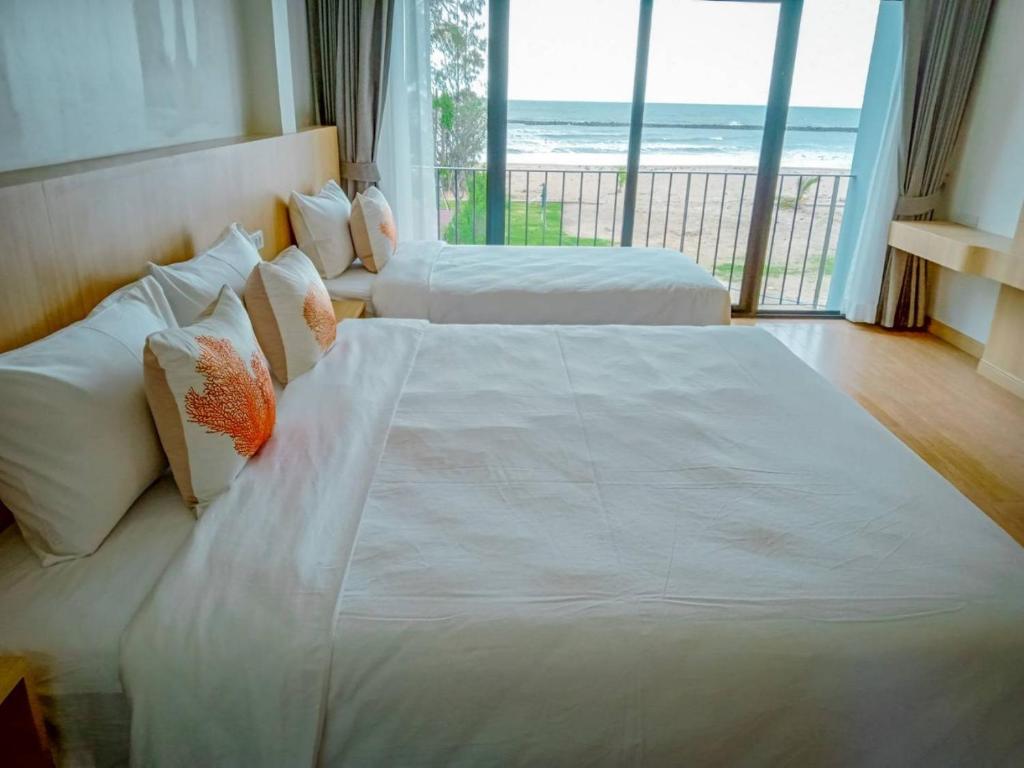 Postel nebo postele na pokoji v ubytování HATCHAO HERITAGE BEACH FRONT RESORT