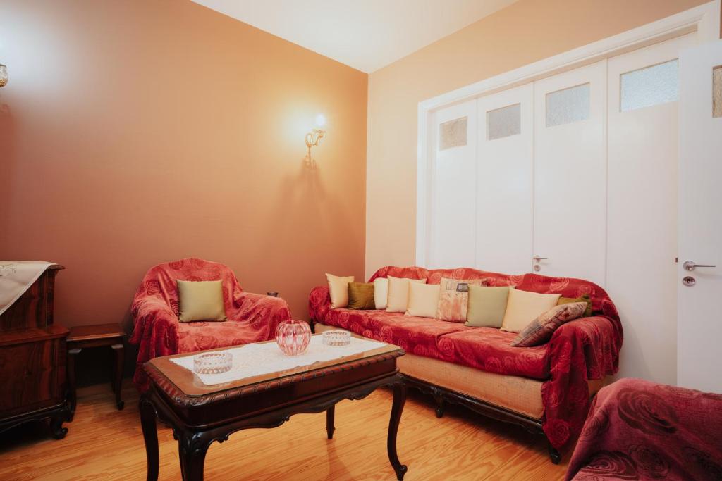 a living room with two red couches and a coffee table at Kalavrita downtown 3 bedroom house for 6 pers in Kalavrita