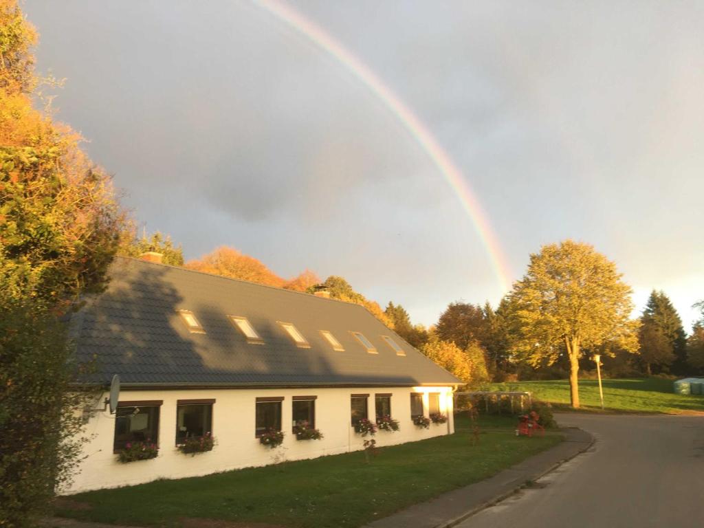 a rainbow in the sky above a house at FeWo Altharmhorst in Kirchnüchel