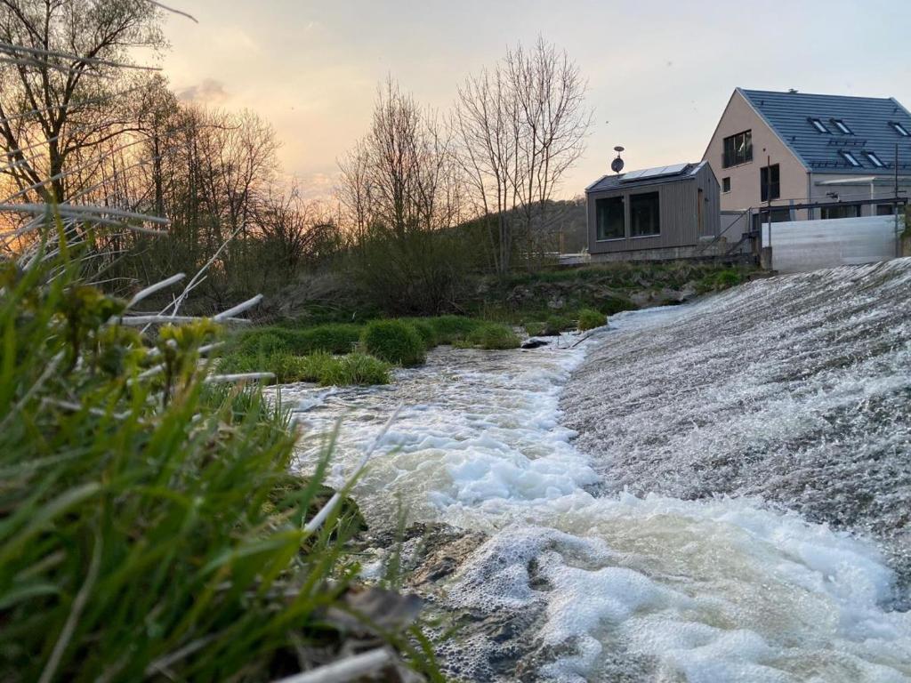 einen Fluss mit einem Haus an der Seite in der Unterkunft Freistehendes Ferienhaus Renkenmühle näher kann man am Wasser nicht wohnen in Eberbach