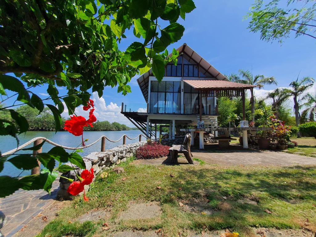 a house on the shore of a body of water at Homestay ALA Riverview Lodge Kota Bharu in Kota Bharu