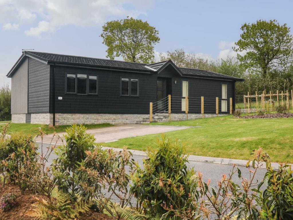 a home with a black house with a yard at Lily in Lifton