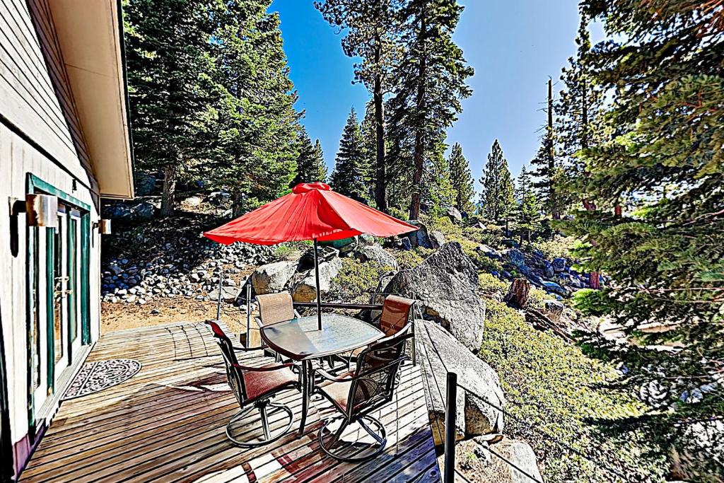 a table and chairs on a deck with an umbrella at Heavenly Retreat in Stateline