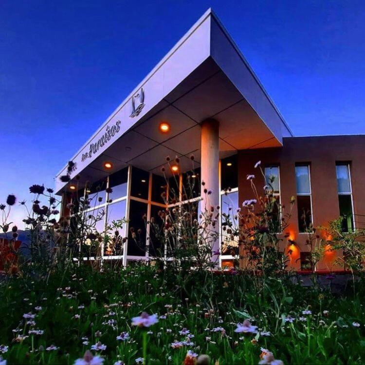 ein Gebäude mit einem Blumenfeld davor in der Unterkunft Complejo Los Paraísos in Potrero de los Funes