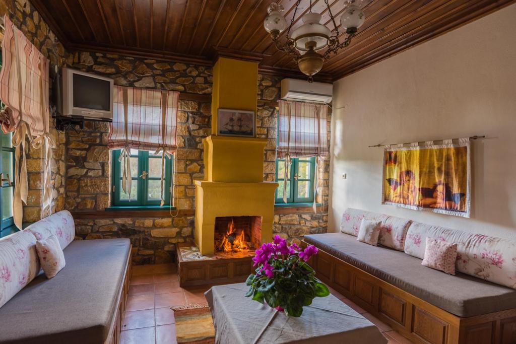 salon z kanapami i kominkiem w obiekcie Platanorema w mieście Agios Ioannis Prodromos