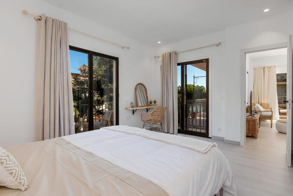 Biała sypialnia z dużym łóżkiem i balkonem w obiekcie Luminoso apartamento en Andalucía del Mar w Marbelli
