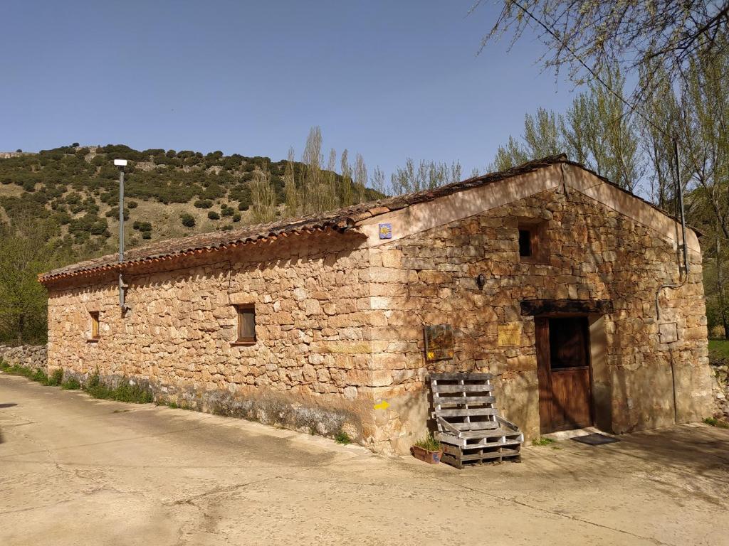 an old stone building with a ladder in front of it at Las Casitas del Salado - La Casita roja in Santamera