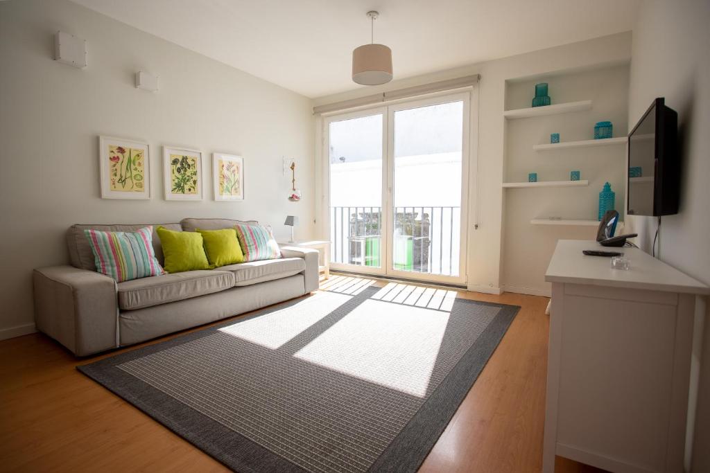 a living room with a couch and a window at Downtown PDL in Ponta Delgada