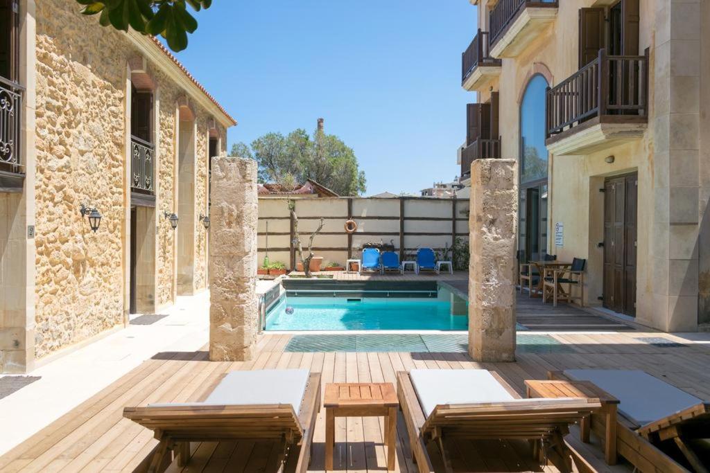 a courtyard with a swimming pool in a house at Volakas Beachfront Suites in Rethymno