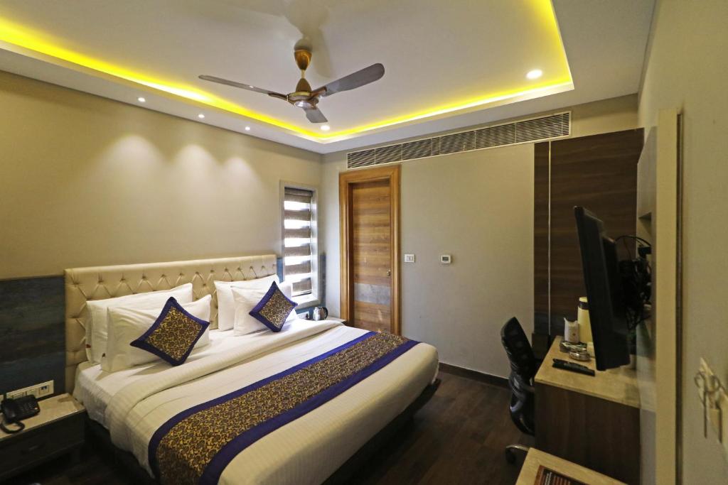 a bedroom with a bed with a ceiling fan at Hotel The IVY Grand With Free Secured Parking in New Delhi