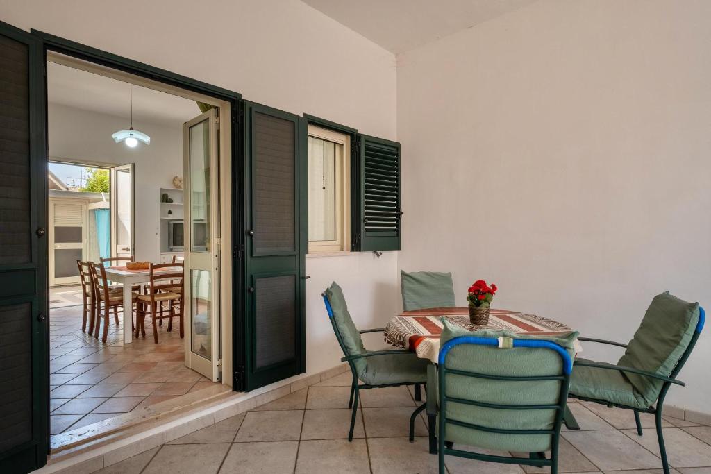 un comedor con mesa y sillas en una habitación en Casa Vacanze Kalocéri, en Torre dell'Orso