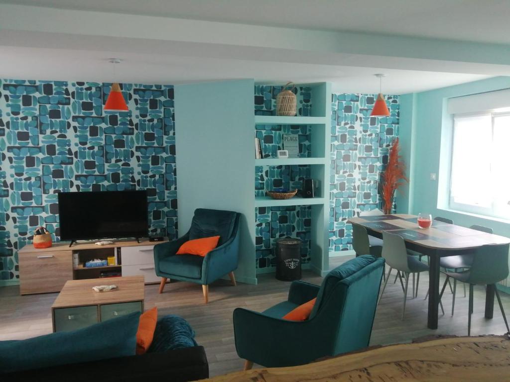 a living room with a table and chairs and a tv at jolie maison centre ville d'Etaples in Étaples