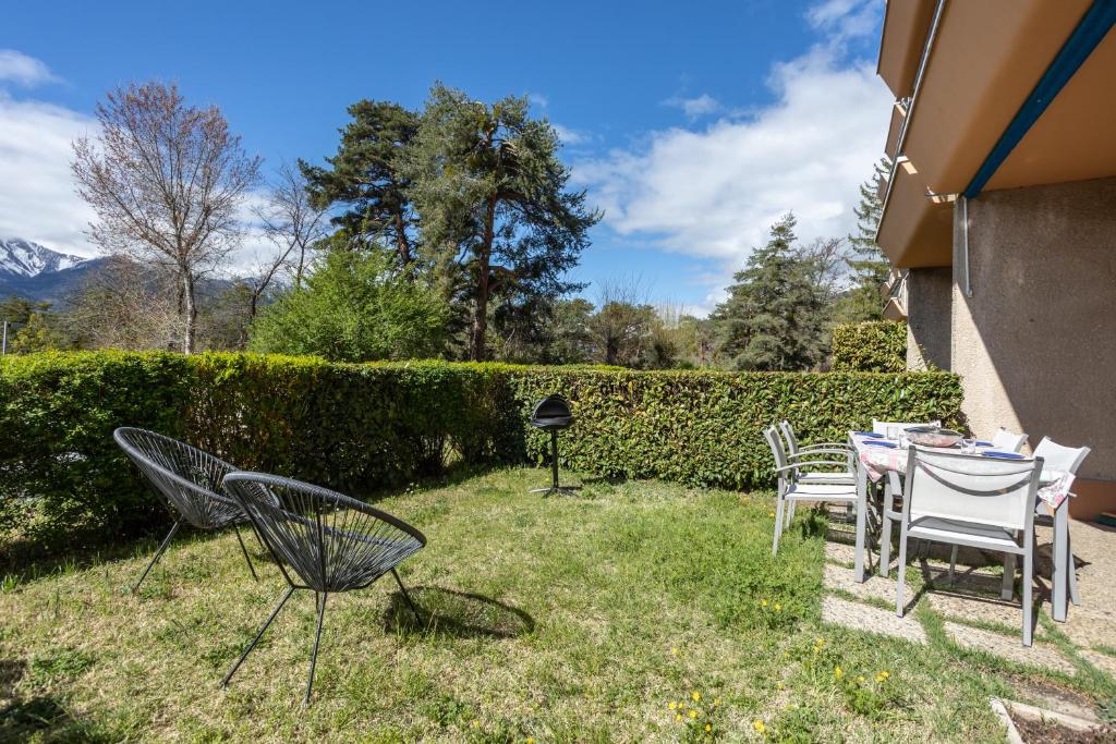 una mesa y sillas en el patio de una casa en La Caravelle, en Embrun