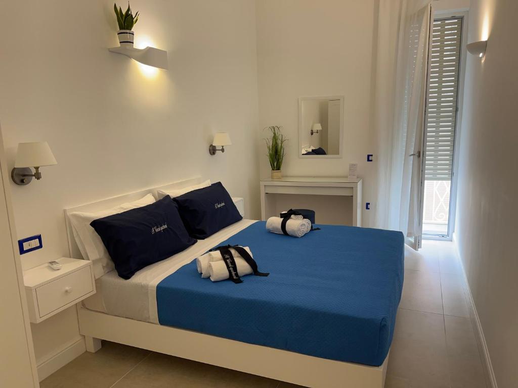 a bedroom with a bed with blue sheets and pillows at St. Vincent Apartment in Castellammare di Stabia