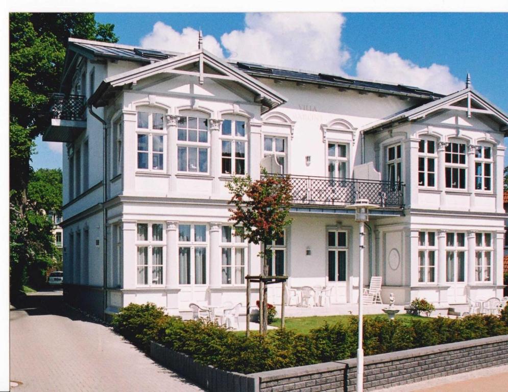 uma grande casa branca com janelas brancas numa rua em Villa Baroni nur 200m vom Ostseestrand entfernt em Bansin