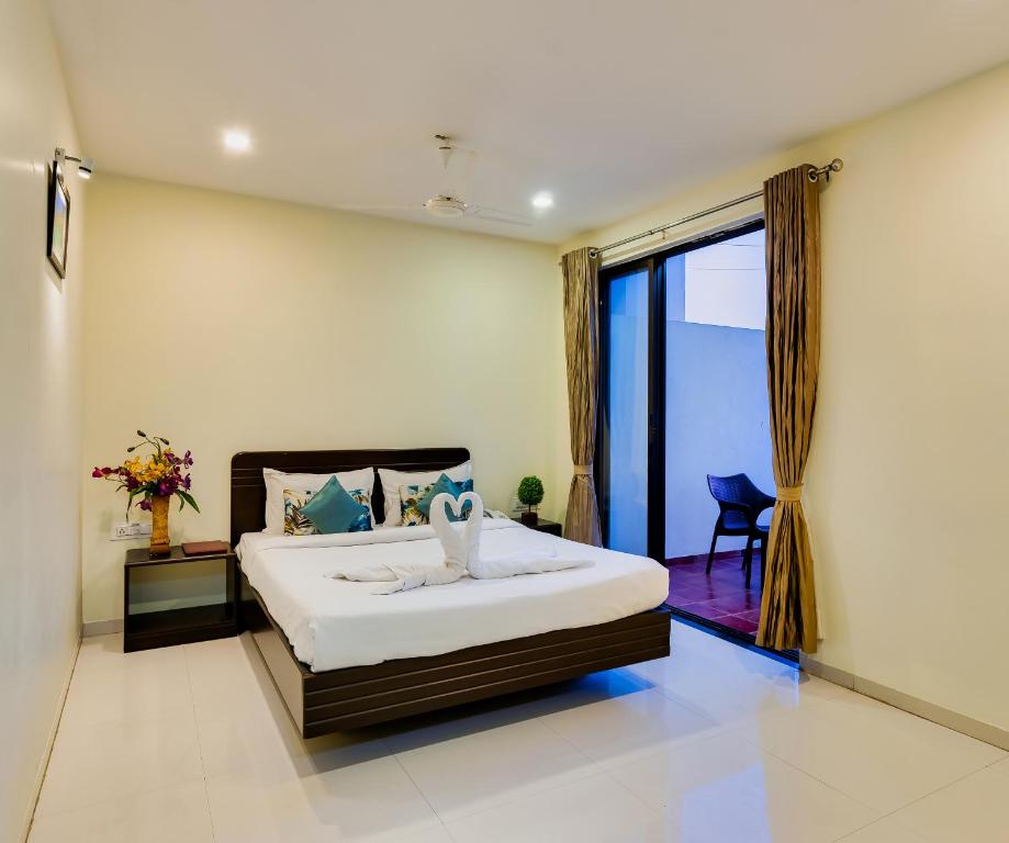 a bedroom with a bed and a large window at Hotel Galaxy Inn-Best Business Hotel in Kolhapur in Kolhapur