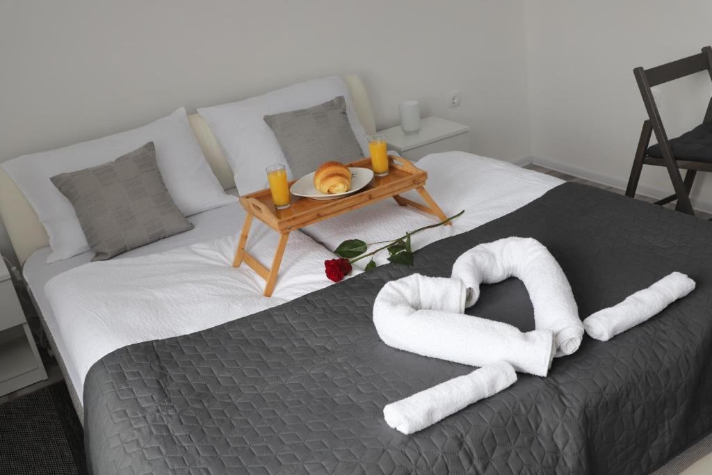 a bed with towels and a tray of food on it at Apartman Normanci near Bizovac thermal spa in Normanci