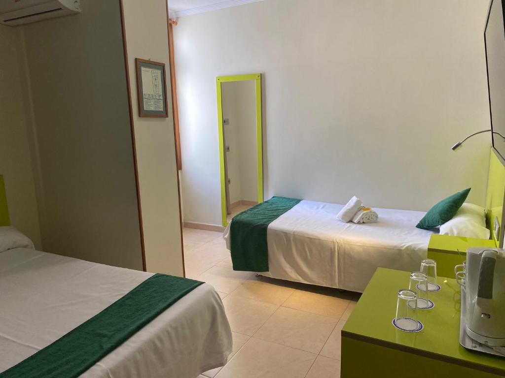 a hotel room with two beds and a mirror at Hotel Andrea´s in Los Cristianos