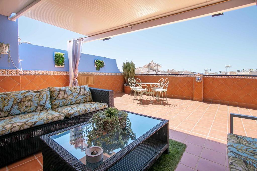 ein Wohnzimmer mit einem Sofa und einem Tisch auf dem Balkon in der Unterkunft LOR PINTADA Apartment in Nerja