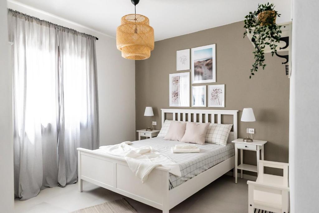 Tortora bed and breakfast في غالنيلي: غرفة نوم بيضاء مع سرير أبيض ونافذة