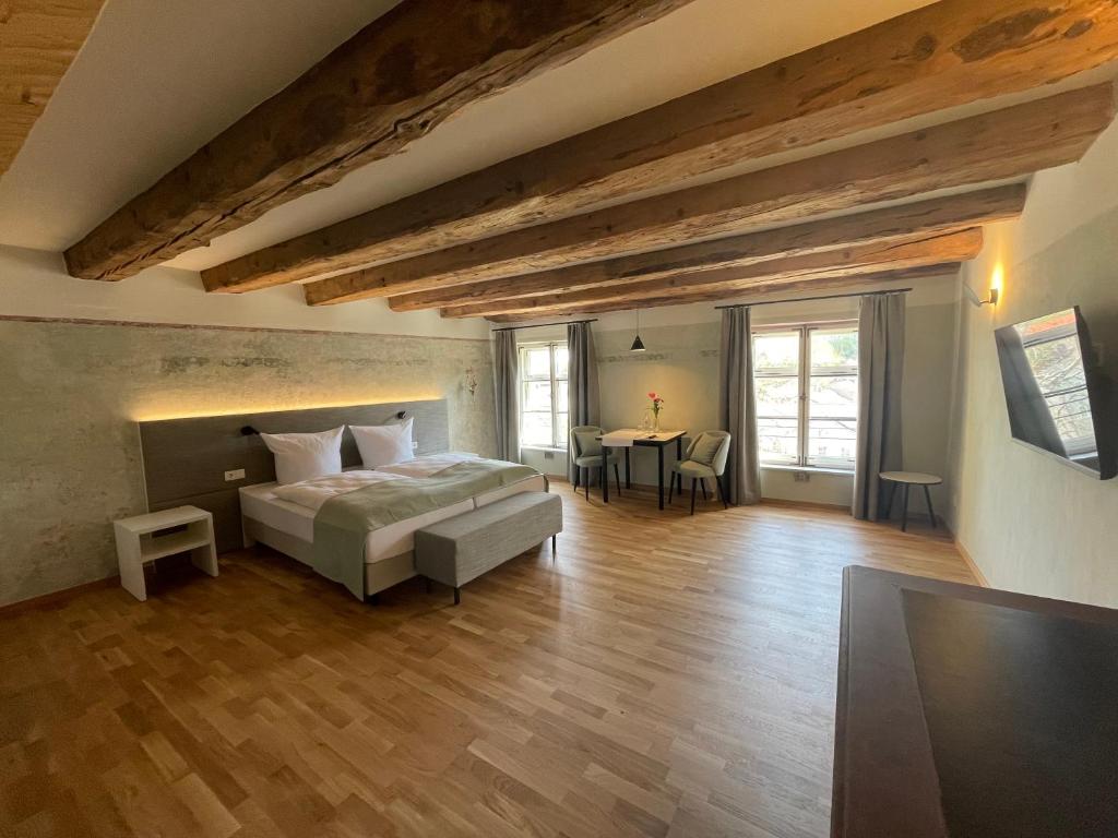 a large bedroom with a bed and a table at Boutique Hotel Hardthaus in Kraiburg am Inn
