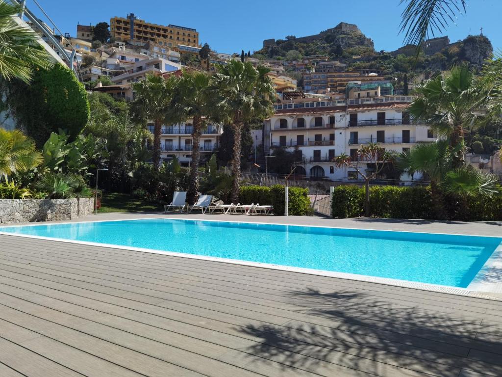 a swimming pool in front of a building at Taormina Argo Apartment by Taormina Holidays in Taormina