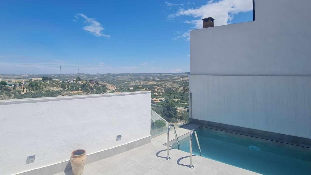 a swimming pool on the side of a building at Casa rural zumbajarros in La Guardia de Jaén