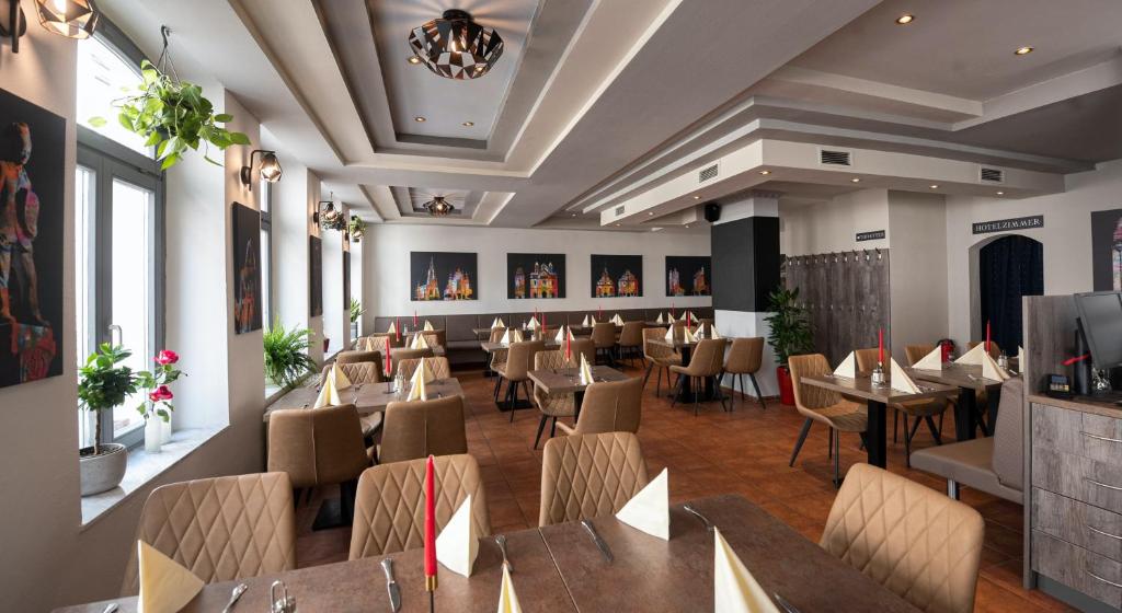 een eetkamer met tafels en stoelen in een restaurant bij Spiranova Restaurant und Hotel in Speyer
