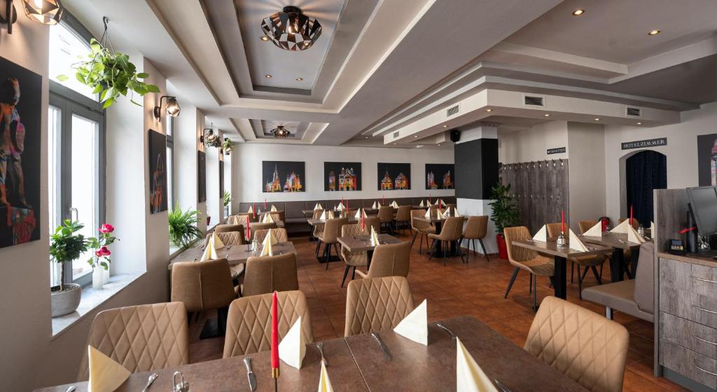 a dining room with tables and chairs in a restaurant at Spiranova Restaurant und Hotel in Speyer