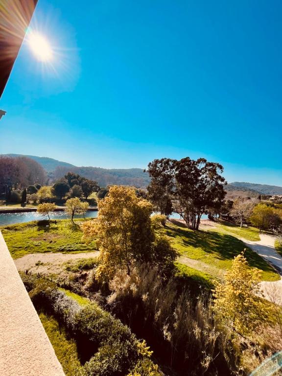 - un balcon avec vue sur la rivière et les arbres dans l'établissement Spacieux Appartement Climatisé  Dernier étage, à Agay