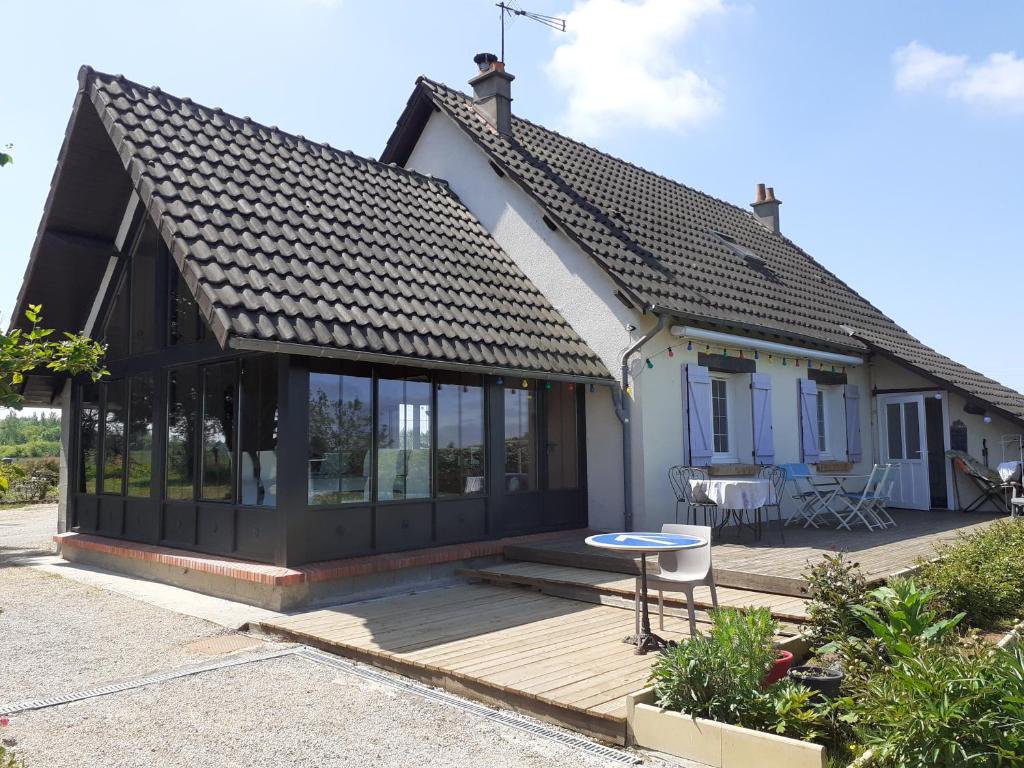 a small house with a wooden deck at Le CHÊNE AUX OISEAUX in Cormeray