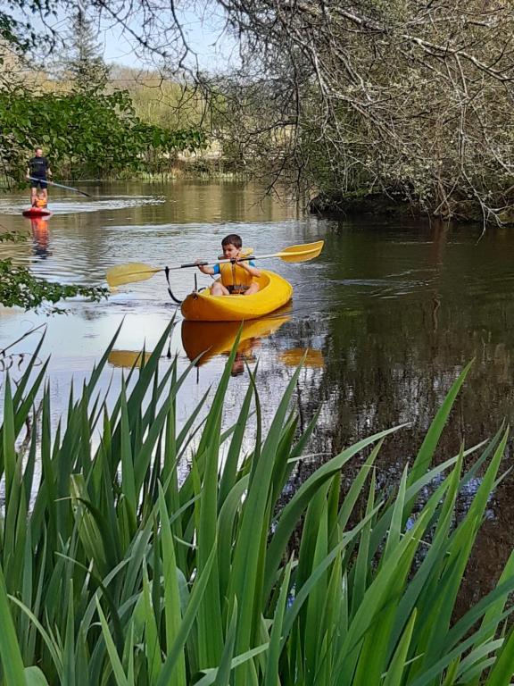 Un ragazzo in un kayak giallo su un fiume di Appartement en lisière de forêt avec étang a Scaër