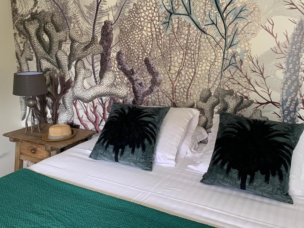 ein Bett mit schwarzen und weißen Kissen und einer Wand in der Unterkunft Ker Ar Men in Minihy-Tréguier