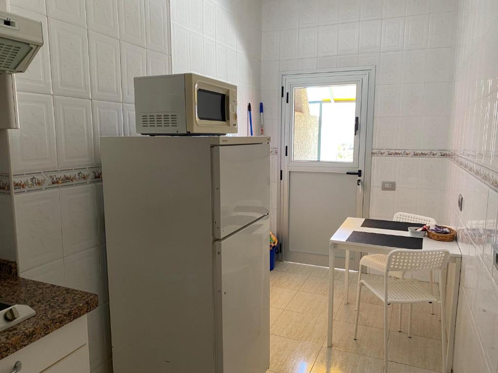 a kitchen with a microwave on top of a refrigerator at Hotel Andrea´s in Los Cristianos