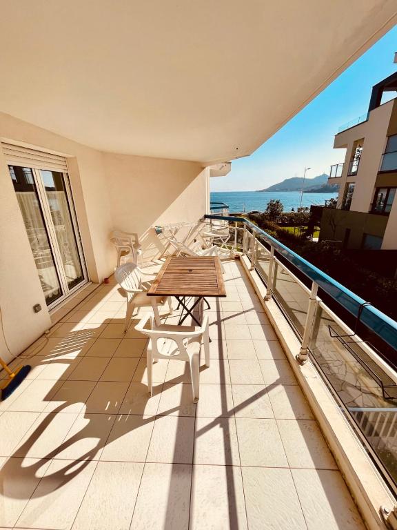 Elle comprend un balcon avec une table et des chaises en bois. dans l'établissement Spacieux Deux pièces en front de mer pour 4 personnes, à Agay